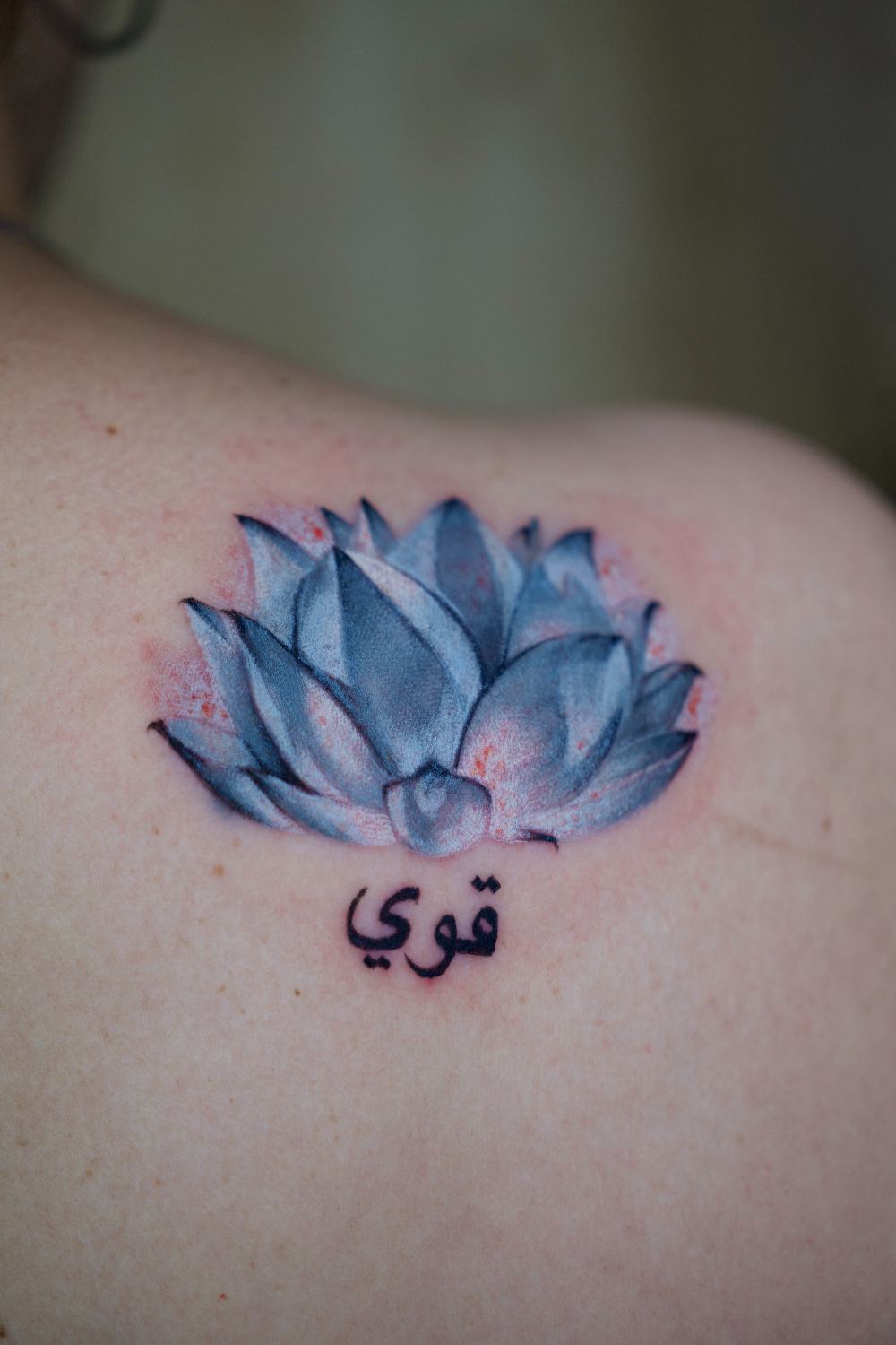 fine line lotus shoulder tattoo with small script by Antwan Rodriguez, West Palm Beach FL