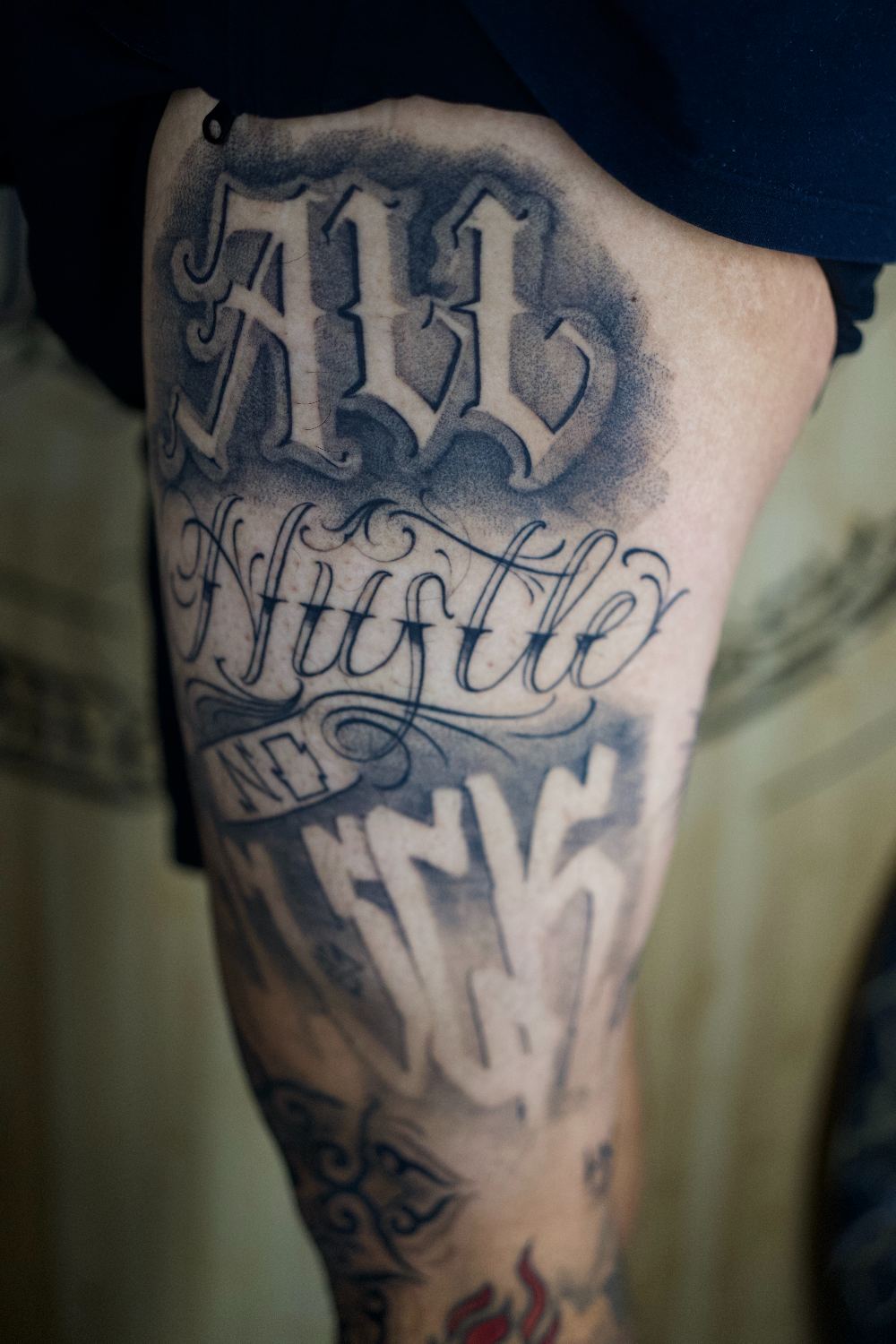 black and gray chicano lettering thigh tattoo by Antwan Rodriguez, West Palm Beach FL
