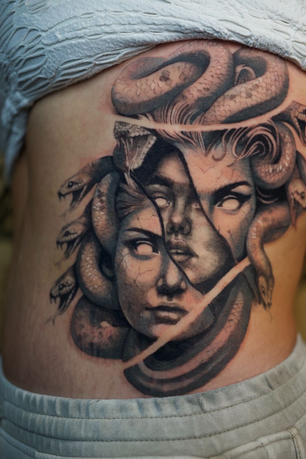black and gray realism Medusa rib tattoo by Antwan Rodriguez, West Palm Beach FL